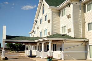 a large white building with a porch in front of it at Country Inn & Suites by Radisson, Saskatoon, SK in Saskatoon