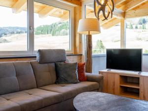 a living room with a couch and a flat screen tv at Chalet Kolibri in Sankt Lambrecht