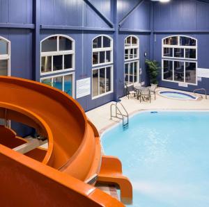 a swimming pool with a slide in a building at Radisson Hotel & Suites Fort McMurray in Fort McMurray