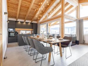 a dining room with a long table and chairs at Grebenzen Top Chalet Mazzel in Sankt Lambrecht