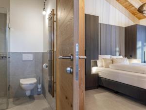 baño con cama, aseo y puerta en Grebenzen Top Chalet Mazzel en Sankt Lambrecht