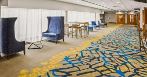 a room with a carpet with chairs and a table at Radisson Hotel Sudbury in Sudbury