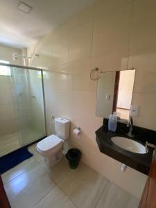 W łazience znajduje się toaleta, umywalka i lustro. w obiekcie Blue House Barra grande w mieście Barra Grande