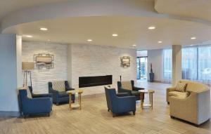 a lobby with chairs and tables and a fireplace at Radisson Hotel Denver Central in Denver