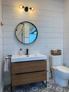 a bathroom with a sink and a mirror and a toilet at Le201chaletlactaureau in Saint-Michel-des-Saints