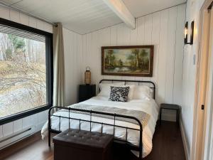 a bedroom with a bed and a large window at Le201chaletlactaureau in Saint-Michel-des-Saints