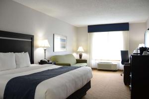 um quarto de hotel com uma cama grande e uma cadeira em Country Inn & Suites by Radisson, Jacksonville, FL em Jacksonville