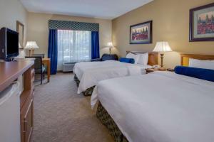 a hotel room with two beds and a television at Country Inn & Suites by Radisson, Jacksonville, FL in Jacksonville