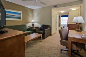 a living room with a couch and a tv at Country Inn & Suites by Radisson, Jacksonville, FL in Jacksonville