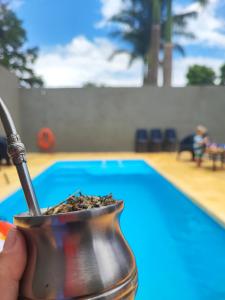 a person holding a drink in a pot next to a pool at La Paz Iguazú in Puerto Iguazú