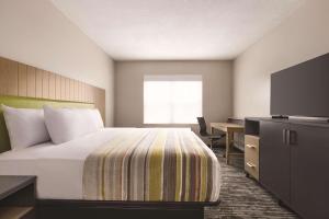 a hotel room with a bed and a desk and a television at Country Inn & Suites by Radisson, Panama City, FL in Panama City