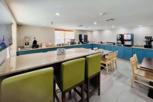 a large kitchen with blue cabinets and green chairs at Country Inn & Suites by Radisson, Panama City, FL in Panama City +22 photos