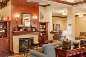 ein Wohnzimmer mit 2 Sofas und einem Kamin in der Unterkunft Country Inn & Suites by Radisson, Port Orange-Daytona, FL in Port Orange