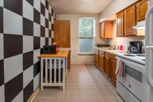 a kitchen with a black and white checkered wall at Alice- The Wonderland Experience in Salem