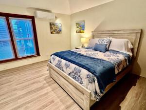 Schlafzimmer mit einem großen Bett mit blauer und weißer Bettwäsche in der Unterkunft Neston in Hamilton