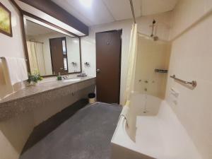 a bathroom with a toilet and a sink and a mirror at Rainbow paradise beach front in Tanjung Bungah