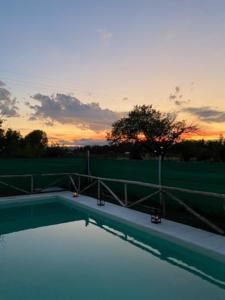 una piscina con puesta de sol en el fondo en Cabaña Natali y Ariel en San Rafael