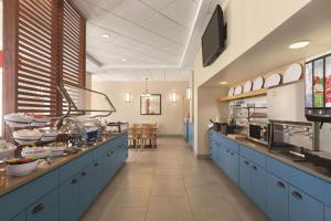 a large kitchen with blue cabinets in a restaurant at Country Inn & Suites by Radisson, Orlando Airport, FL in Orlando