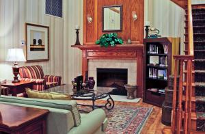 Country Inn & Suites by Radisson, Jacksonville West, FL في جاكسونفيل: غرفة معيشة مع أريكة ومدفأة