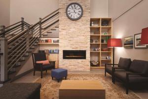 a living room with a clock on a brick wall at Country Inn & Suites by Radisson, Bradenton-Lakewood-Ranch, FL in Bradenton