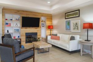 a living room with a couch and a tv at Country Inn & Suites by Radisson, Tampa Airport North, FL in Tampa