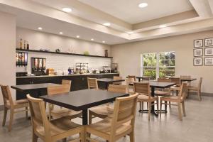 un comedor con mesas, sillas y una barra en Country Inn & Suites by Radisson, Tampa-Brandon, FL en Tampa