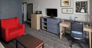 sala de estar con escritorio y silla roja en Country Inn & Suites by Radisson, Canton, GA, en Canton