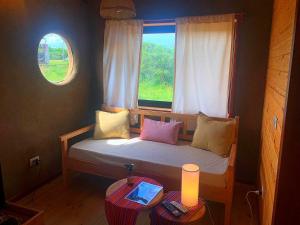 Dormitorio pequeño con cama y ventana en Nao Tem Fim en Punta del Diablo