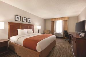 a hotel room with a large bed and a television at Country Inn & Suites by Radisson, Lawrenceville, GA in Lawrenceville