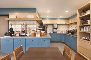 uma cozinha com armários azuis e uma mesa de madeira em Country Inn & Suites by Radisson, Lawrenceville, GA em Lawrenceville