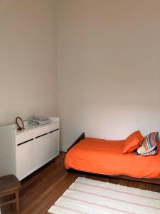 a bedroom with an orange bed and a white cabinet at Morada Montevideana in Montevideo