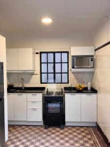 a kitchen with white cabinets and a stove top oven at Morada Montevideana in Montevideo