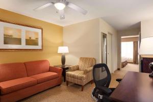 salon z kanapą i krzesłem w obiekcie Country Inn & Suites by Radisson, Savannah I-95 North w mieście Port Wentworth
