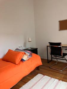 a bedroom with an orange bed and a chair at Morada Montevideana in Montevideo