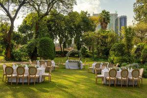 um grupo de mesas e cadeiras num parque em Fairview Hotel Nairobi em Nairobi