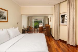 a bedroom with a large white bed and a desk at Fairview Hotel Nairobi in Nairobi