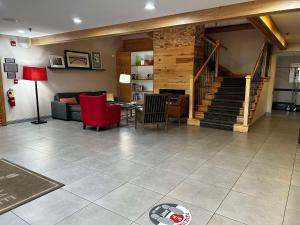 a living room with a staircase and red chairs at Country Inn & Suites by Radisson, Columbus, GA in Columbus