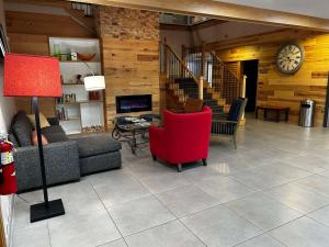 a living room with a couch and a red chair at Country Inn & Suites by Radisson, Columbus, GA in Columbus