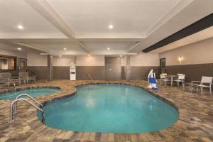 uma piscina num quarto de hotel com mesas e cadeiras em Country Inn & Suites by Radisson, Savannah Midtown, GA em Savannah