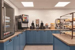 a kitchen with blue cabinets and a counter with bread at Country Inn & Suites by Radisson, Savannah Midtown, GA in Savannah