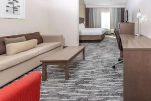 a living room with a couch and a desk in a hotel room at Country Inn & Suites by Radisson, Smyrna, GA in Smyrna