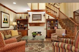 a living room with a staircase and a table and chairs at Country Inn & Suites by Radisson, Macon North, GA in Macon