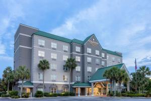 瓦爾多斯塔的住宿－Country Inn & Suites by Radisson, Valdosta, GA，棕榈树酒店前的 ⁇ 染