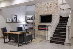 a living room with a fireplace and a tv at Country Inn & Suites by Radisson, Valdosta, GA in Valdosta