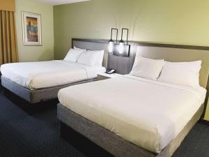Habitación de hotel con 2 camas con sábanas blancas en Park Inn by Radisson Albany, en Albany