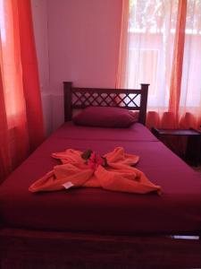 uma cama com um cobertor vermelho com uma janela em Anluka-House # 2 em Puerto Jiménez