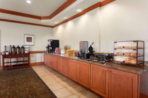 a lobby with a counter with aasteryasteryasteryasteryasteryasteryasteryasteryastery at Country Inn & Suites by Radisson, Tifton, GA in Tifton