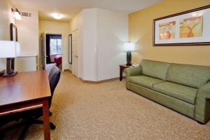 a living room with a green couch and a desk at Country Inn & Suites by Radisson, Helen, GA in Helen