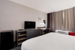 a hotel room with a bed and a desk with a television at Country Inn & Suites by Radisson, Augusta at I-20, GA in Augusta