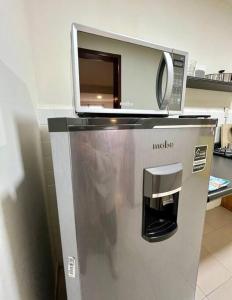 トゥランシンゴにあるDepto. equipado, Dos Habitaciones, Centro Tulancingoの冷蔵庫の上に置かれた電子レンジ
